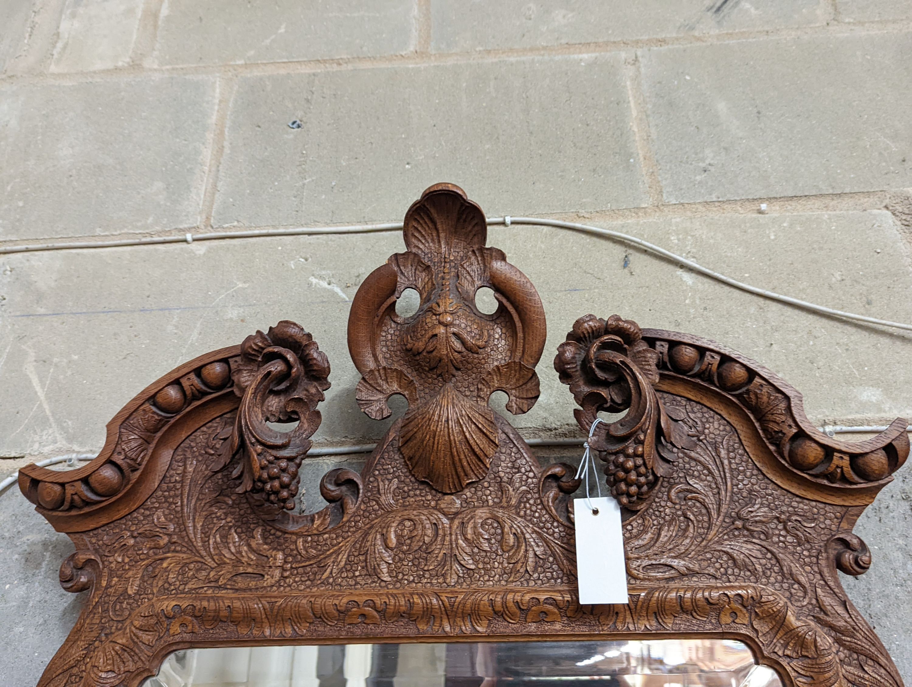 An 18th century style carved wood wall mirror, width 64cm, height 124cm